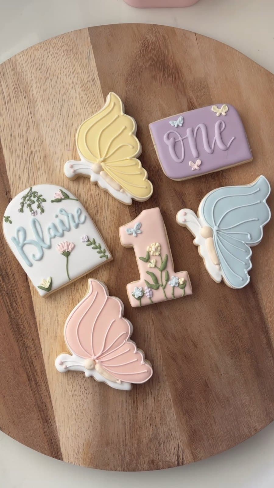 Pastel butterfly cookies with a name, the word one, and a number 1